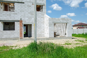 Building site of a house under construction made from white foam concrete blocks. Building new frame of home.