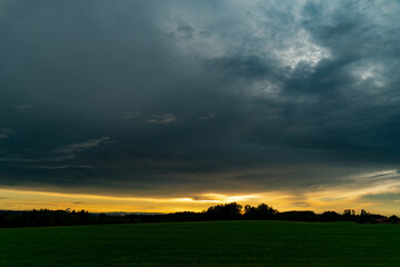 Fototapeta na wymiar sunset over field, dark clouds, cloud cover, thunderstorm