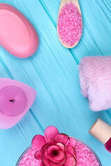 Obraz na płótnie Canvas Vertical shot flat lay pink bathroom accessories on blue wood.