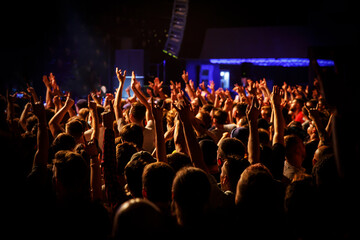 People at a public event. Crowd with raised hands at a concert.