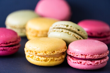 Obraz na płótnie Canvas Macarons on dark background, colourful french cookies macarons. 