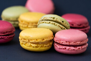 Fototapeta na wymiar Macarons on dark background, colourful french cookies macarons. 