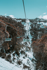 People in winter enjoying the snowy mountains where are practised plenty of activities such as skiing and snowboarding with a clear sky and some clouds on the horizon.