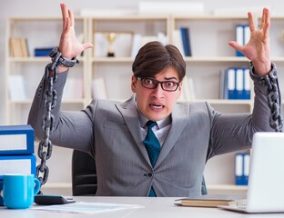 Businessman tied with chains to his work
