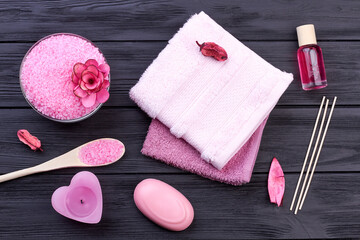 Obraz na płótnie Canvas Flat lay pink bath body care accessories on dark wood.