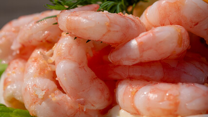 Close up of peeled fresh shrimps on white bread, making a delicious Swedish shrimp sandwich (räkmacka).
Seafood and food preparation concept.