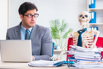 Businessman working with skeleton in office