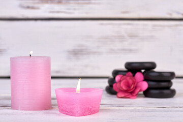 Obraz na płótnie Canvas Pink wax candles with stones and flower for spa.