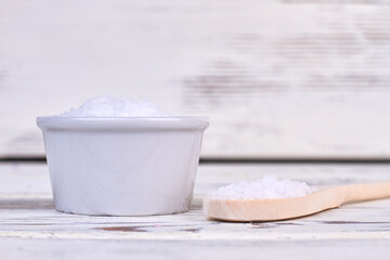 Fototapeta na wymiar Pile of white salt with rustic wooden spoon.