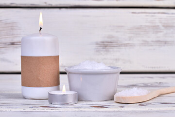 Fototapeta na wymiar Candles and white salt for spa treatment on wooden desk.