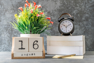 August 16th. August 16 wooden cube calendar with blur objects on background.