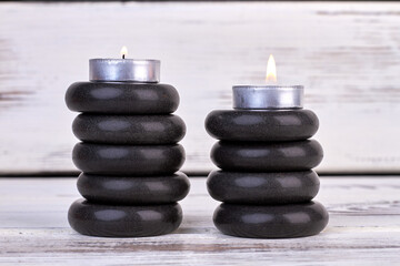 Stacks of black stones with candles for spa therapy.