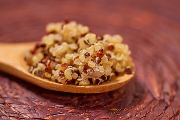 Quinoa cooked in a wooden spoon. Healthy vegan food concept. Macro shot