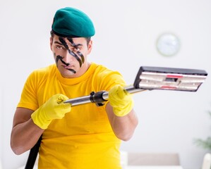 Funny man in military style cleaning the house