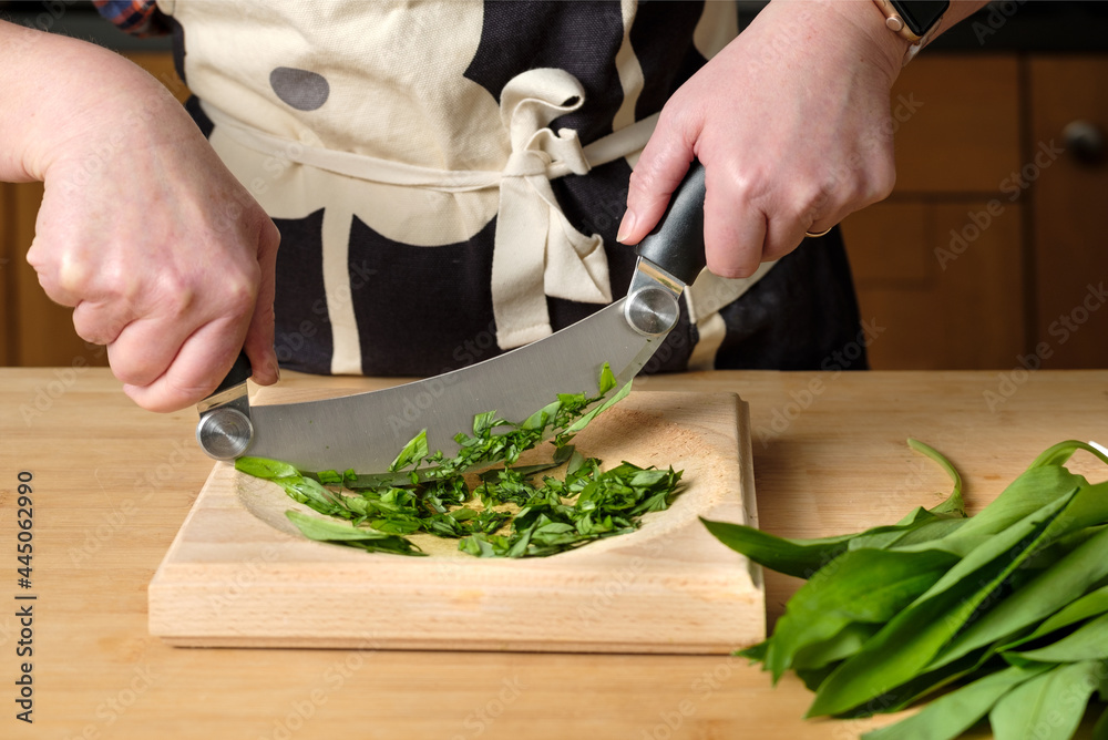 Wall mural Shot of chef's hands cutting greens