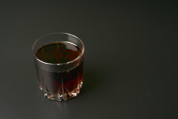 A full glass of soda on a black background.