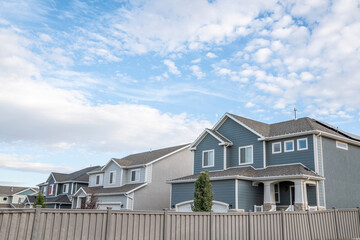 Two-storey houses in a residential area against a beautiful sky and clouds background