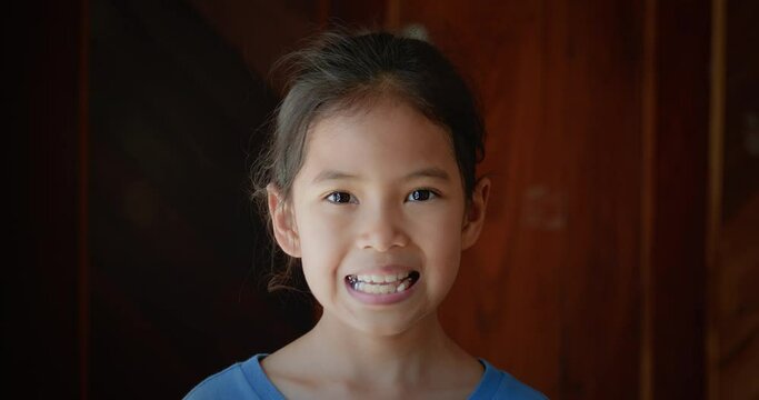 Portrait of asian child girl open mouth showing rocking milk teeth