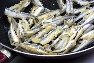 Fried fish in pan. Fasting food on dark background 