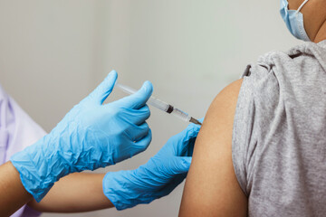 Female doctor giving shot vaccine patient shoulder. Vaccination prevention virus covid19 pandemic. - obrazy, fototapety, plakaty