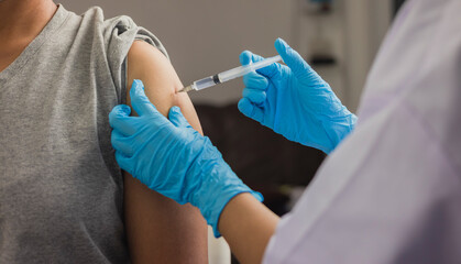 Female doctor giving shot vaccine patient shoulder. Vaccination prevention virus covid19 pandemic.