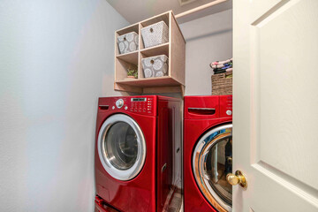 Small laundry room interior with red laundry machines