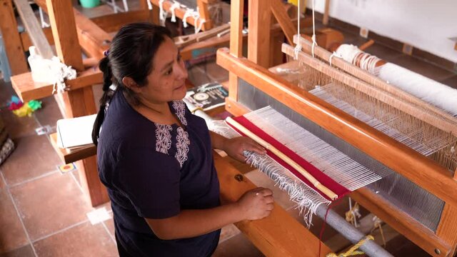 latin woman working in artisan fabric workshop in mexico