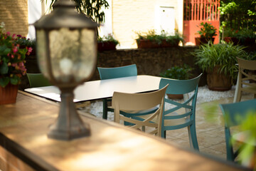 Garden patio with table and chairs. Gardening in pots. Lamp. Cozy environment for relaxation.