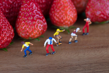 Roller skating enthusiasts are exercising by the strawberry