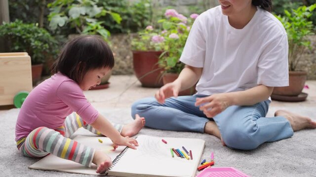 slow motion  happy asian mother teach her child writing at home lovely baby girl learning to write in the yard with her mother happy asian family 4k lifestyles