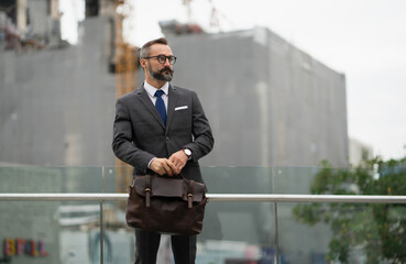  Lifestyle businessman in suit standing on the background of a construction building in the city.