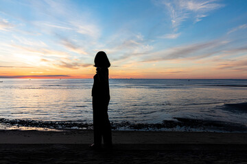 Fototapeta premium silhouette, Romantic woman on the beach for looking sunset over the sea
