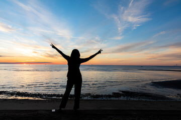 silhouette, Romantic woman  on the beach for looking sunset over the sea