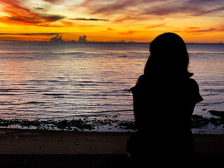 silhouette, Romantic woman  on the beach for looking sunset over the sea