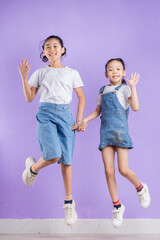 Obraz premium Portrait of two Asian girls on purple background