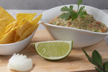 Guacamole and nachos in white bowls. Mexican food.