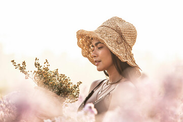 Soft focus of beautiful asian woman holding a basket of margaret flowers in the pink cutter flowers...
