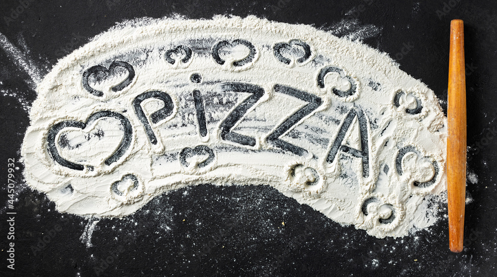 Poster word pizza and heart is written on flour with rolling pin, top view. abstract baking background