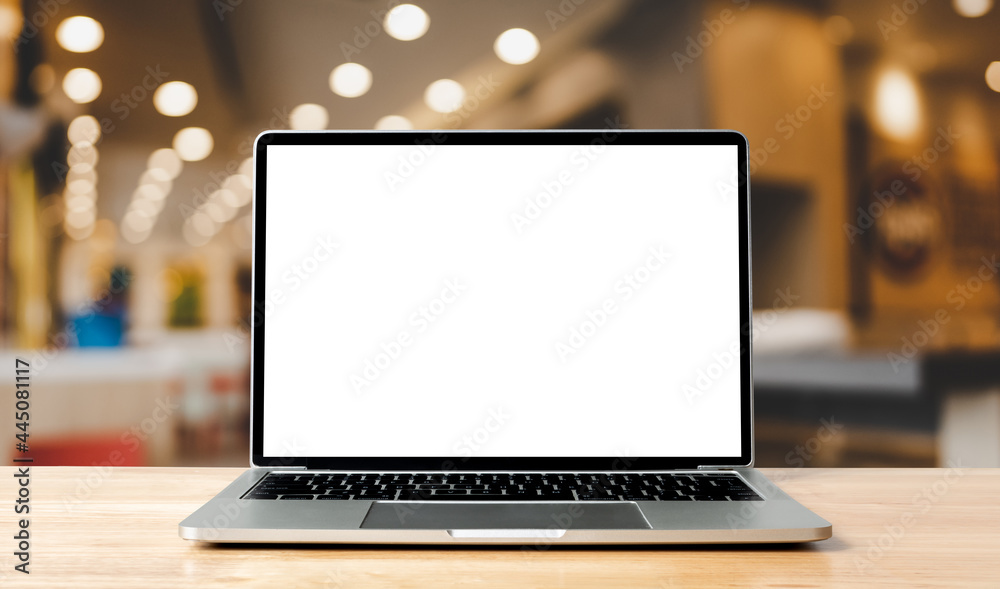 Fototapete laptop blank screen on wood table with blurred coffee shop cafe interior background and lighting bok