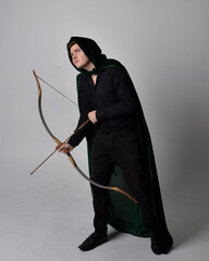 Full length portrait of a  brunette man wearing black shirt, waistcoat and a green velvet cloak...