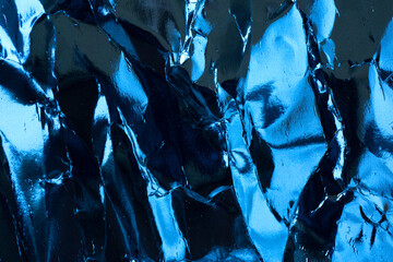 Crumpled blue foil paper texture.