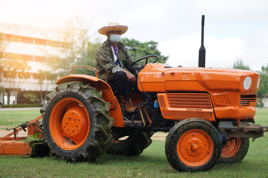 Asian farmer driving a tractor. 