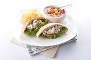 chicken salad kebab open pocket bread serve with tomato soup and crispy potato chips combo set  in white background asian vegan halal menu