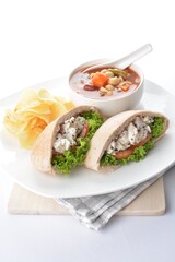 chicken salad kebab open pocket bread serve with tomato soup and crispy potato chips combo set  in white background asian vegan halal menu