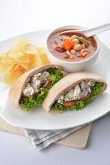 chicken salad kebab open pocket bread serve with tomato soup and crispy potato chips combo set  in white background asian vegan halal menu