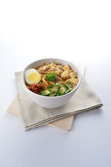 Malay mee rebus noodle with boiled egg, tofu, green chilli, sambal chilli sauce and hot thick curry gravy soup bowl in white background asian halal menu