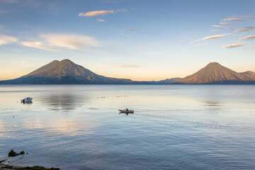 Spectacular landscape of a lonely fisherman in a boat at sunrise - Panajachel, Lake Atitlán, in the Guatemalan highlands, Central America