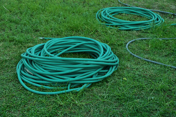 Green hoses for lawn irrigation, folded into several coils