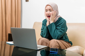 Asian Muslim businesswoman using a laptop working from home
