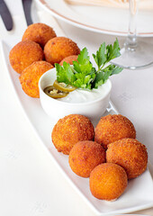 Meat balls with white sauce and olives.